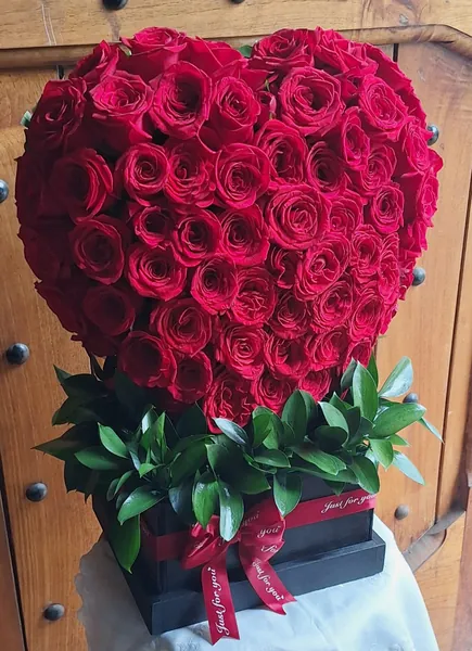 Corazón de rosas rojas en caja de madera negra
