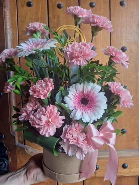 Arreglo de claveles y gerberas rosadas en caja de cartón