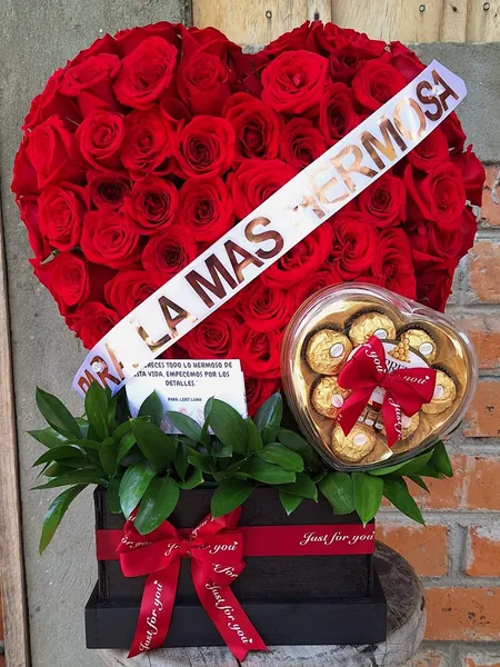 Corazón de rosas rojas con chocolates en caja de madera
