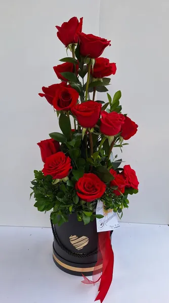 Caja negra con rosas rojas en cascada y corazón dorado