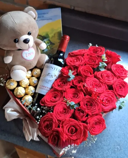 Regalo con osito, vino y corazón de rosas rojas