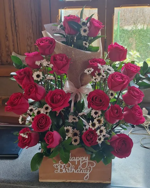 Caja de rosas fucsia con letrero de cumpleaños