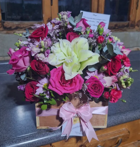 Caja de madera con rosas fucsia, lirio blanco y flores lila