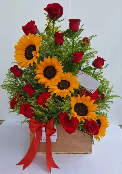 Arreglo de girasoles y rosas rojas en cajón de madera