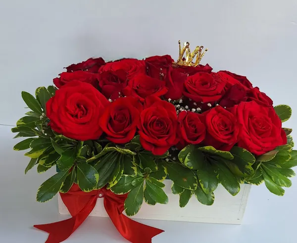 Caja de rosas rojas con corona decorativa dorada