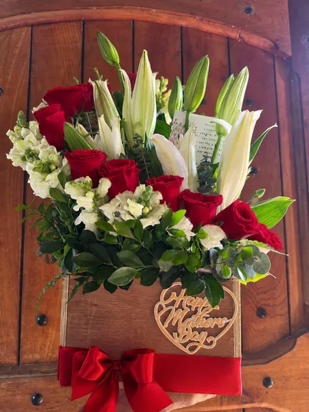 Caja de madera con rosas rojas y lirios blancos para mamá