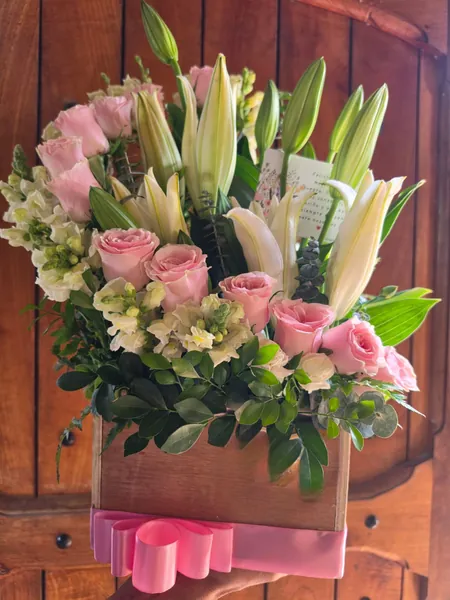 Caja de madera con rosas rosadas y lirios blancos en Salamá