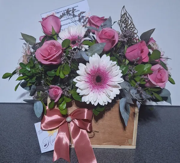 Caja de madera con rosas rosadas y gerbera blanca