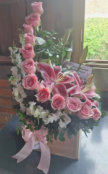 Caja de madera con rosas rosadas y lirio stargazer
