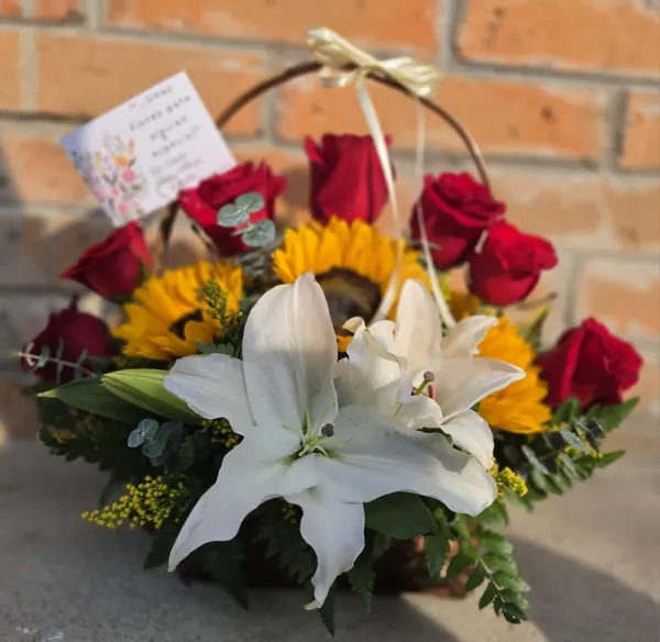 Canasta de rosas rojas con girasoles y azucenas