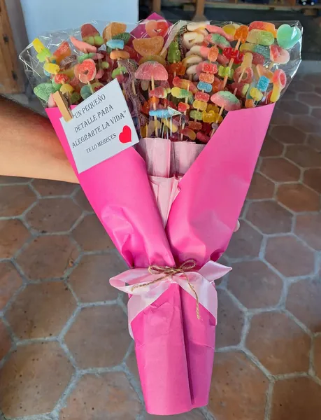 Ramo de dulces y gomitas envuelto en papel rosa