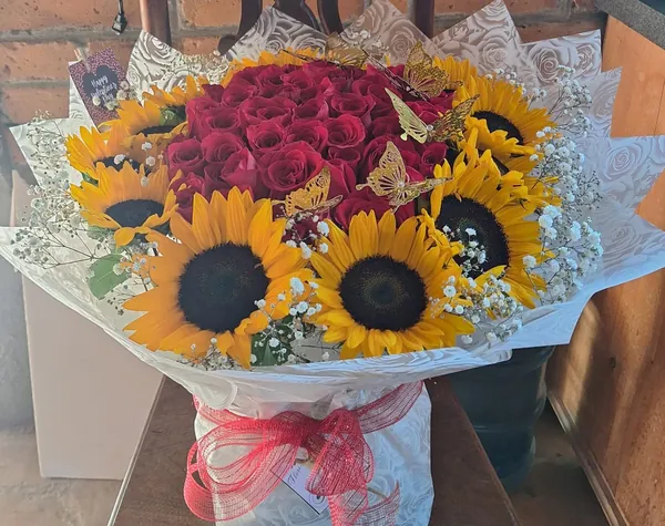 Ramo de rosas rojas y girasoles con mariposas doradas