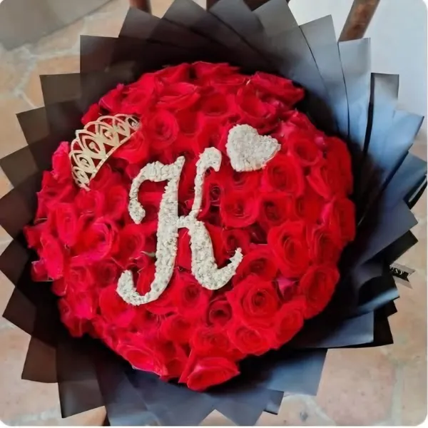 Ramo de rosas rojas con corona e inicial decorativa