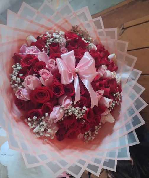 Ramo de rosas rojas y rosadas con lazo satinado