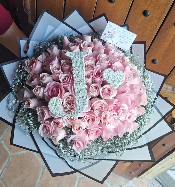 Ramo de rosas rosadas con inicial decorativa
