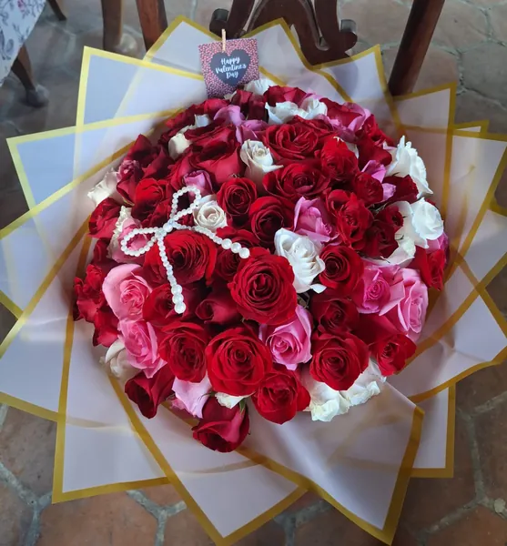 Ramo de rosas rojas, blancas y rosadas con lazo de perlas