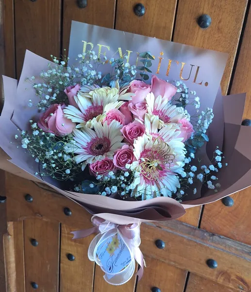 Ramo de gerberas blancas y rosas rosadas en papel malva