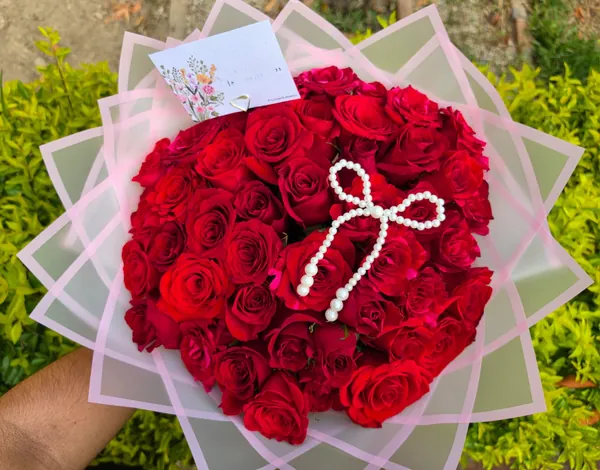 Ramo circular de rosas rojas con lazo de perlas
