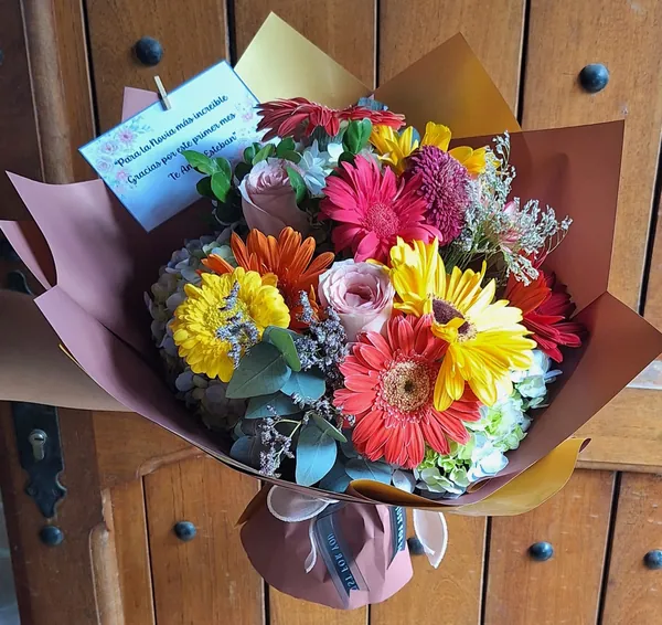 Ramo colorido de gerberas y rosas en envoltura cobre