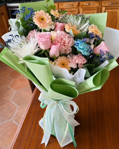Ramo de flores mixtas en tonos pastel con envoltura verde menta