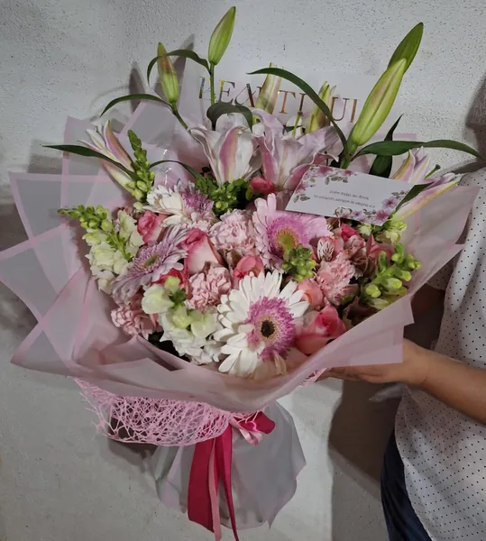 Ramo de lirios blancos y gerberas rosadas en papel translúcido