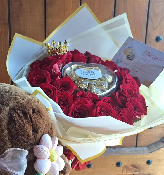 Ramo de rosas rojas con corona dorada y chocolates