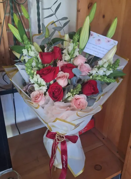 Ramo de rosas rojas y rosadas con capullos de lirio blanco