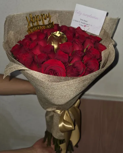 Ramo de rosas rojas en envoltura rústica con topper dorado