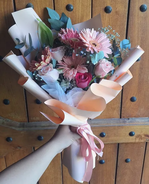 Ramo de gerberas y rosas rosadas con envoltura durazno